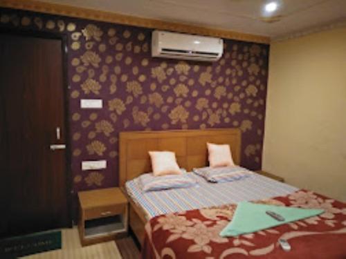 Bapu Guest House,Bhubaneswar في بوهفانيشفار: غرفة نوم بسرير وجدار بالورود