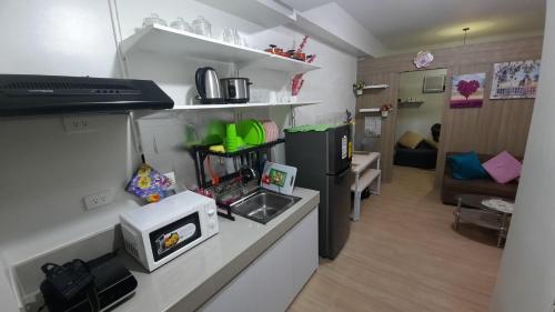 a room with a kitchen and a living room at Amaze365 Holiday Homes Condotel at Trees Residence Fairview in Manila