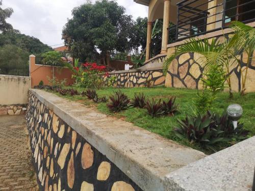 a retaining wall in front of a house with plants at Good Times in Kampala