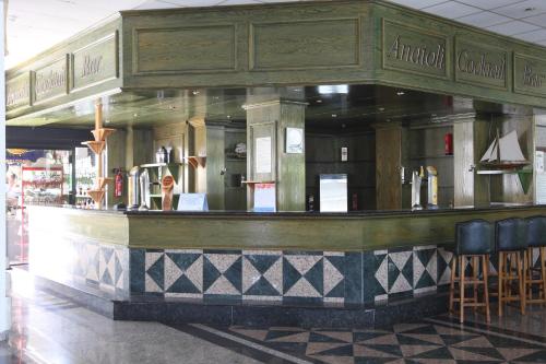a bar in a restaurant with a green at Tsokkos Gardens Hotel in Protaras