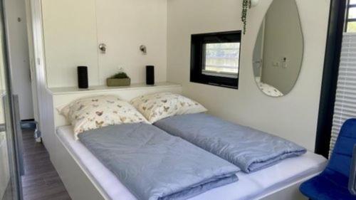a bed with two pillows on it in a room at Hausboot freiZeit - LP1 in Höxter