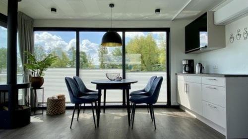 eine Küche mit einem Tisch und Stühlen sowie einem großen Fenster in der Unterkunft Hausboot freiZeit - LP1 in Höxter
