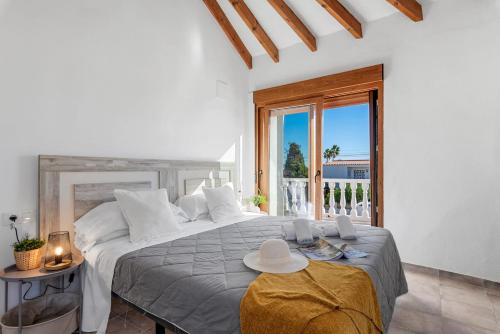 a white bedroom with a large bed and a window at Villa K9 Ortenbach in Ifach