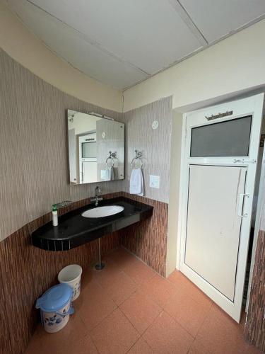 a bathroom with a sink and a large mirror at The Sojourn in Dharamshala