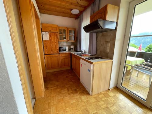 a small kitchen with wooden cabinets and a stove at Pension Sedlak in Millstatt