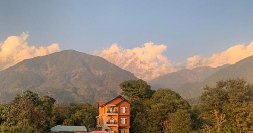 a house in front of a mountain range with mountains at The Sojourn in Dharamshala