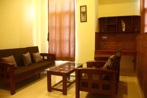 a living room with a couch and a table and chairs at The Sojourn in Dharamshala