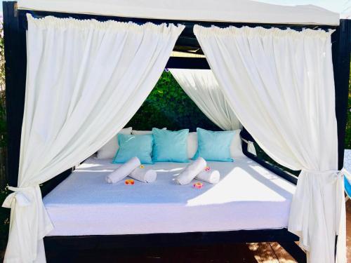 Cama con almohadas y cortinas azules y blancas en Sebastian's House, en Coín