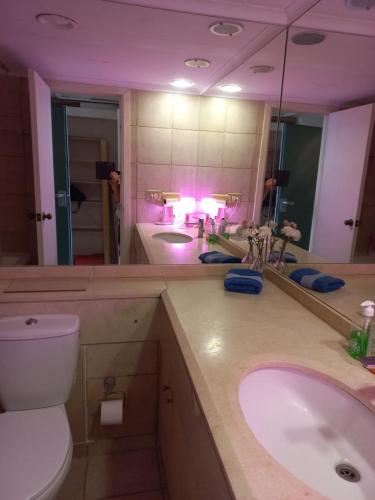 ein Badezimmer mit einem Waschbecken, einem WC und einem Spiegel in der Unterkunft Stunning Studio on The Water in Haifa