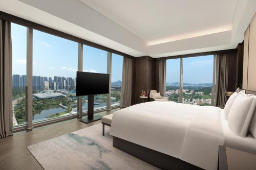 a bedroom with a large white bed and large windows at Crowne Plaza Jiangmen Binjiang by IHG in Jiangmen