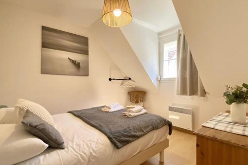 une petite chambre avec un lit dans un grenier dans l'établissement Maison 4 personnes avec jardin et parking, au Crotoy