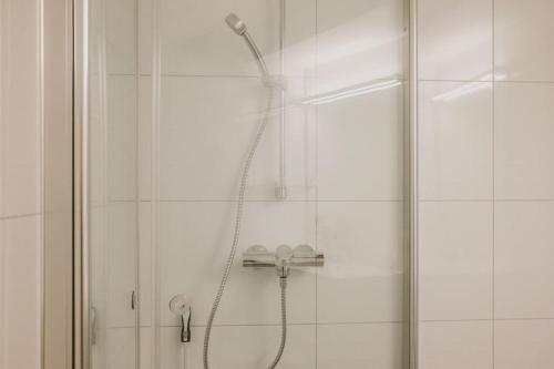 a shower with a shower head in a bathroom at Leilighet i nybygg in Svolvær