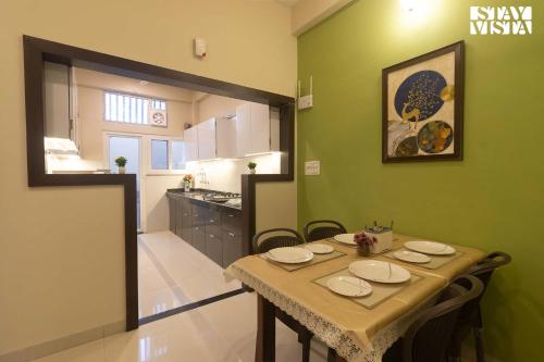 uma sala de jantar com uma mesa e uma cozinha em StayVista's Villa Orchid - Pet-Friendly Villa with Lawn, Bonfire & Indoor-Outdoor Games em Ujaim