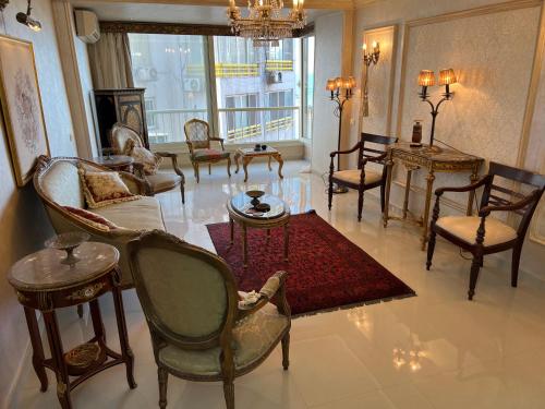 Sea View Luxury Apartment في الإسكندرية: غرفة معيشة مليئة بالاثاث ونافذة كبيرة