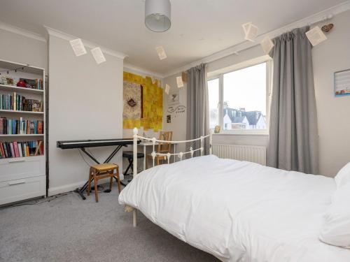 a bedroom with a bed and a desk with a piano at Pass the Keys Family holiday home by the sea with free parking in Hove