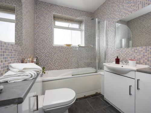 a bathroom with a toilet and a tub and a sink at Pass the Keys Family holiday home by the sea with free parking in Hove