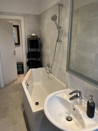een witte badkamer met een wastafel en een douche bij Appartement zwischen Messe und Innenstadt in Leipzig