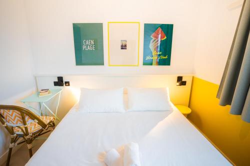 a bedroom with a white bed and a chair at The People Caen in Caen
