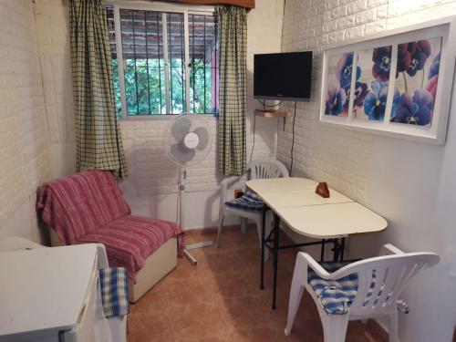 una pequeña sala de estar con mesa y silla en Las Palmitas, en Atlántida