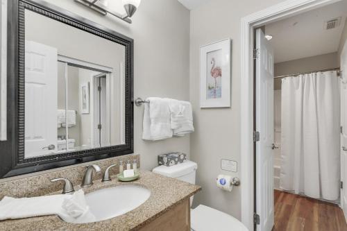 a bathroom with a sink and a toilet and a mirror at Windancer 211 in Destin