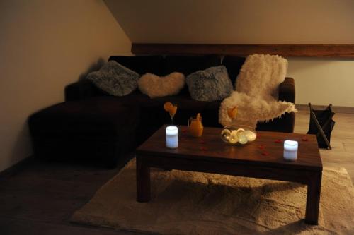a living room with a black couch and a coffee table at Ecrin d' Amour suite romantique avec Jacuzzi in Castels