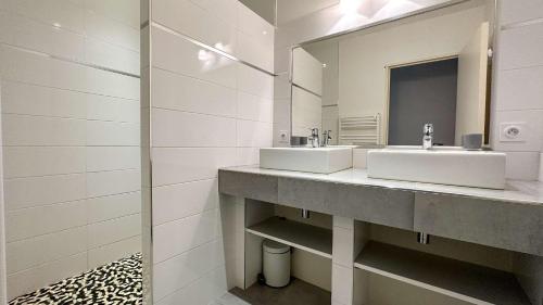 a bathroom with two sinks and a mirror at Villa avec piscine privée, à proximité de la plage et du centre de thalasso in Ars-en-Ré