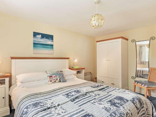 a bedroom with a bed with a blue and white blanket at 1 Bed in Lyme Regis WHOUS in Axminster