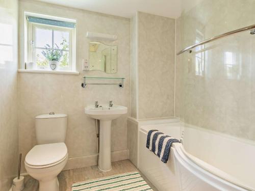 a bathroom with a toilet and a sink and a tub at 1 Bed in Lyme Regis WHOUS in Axminster