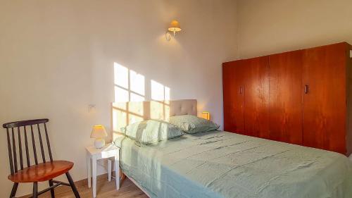 a bedroom with a bed and a wooden cabinet at Jolie maison avec parking et jardin au cœur de Loix in Loix