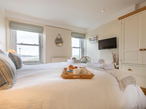 Una cama blanca con una bandeja de toallas. en 3 Bed in Instow INSBR en Instow