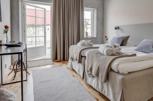 two beds in a room with a window at Örums Nygård Gårdshotell in Löderup