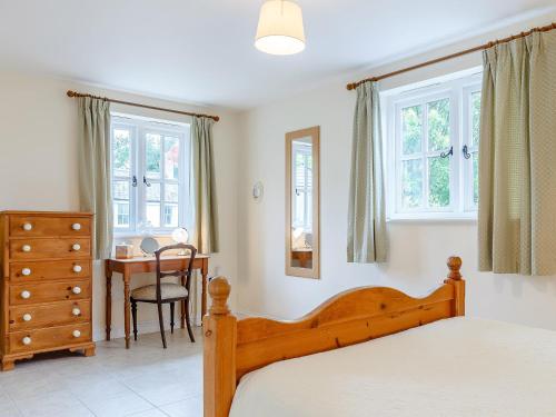 a bedroom with a bed and a table and windows at 2 Bed in Truro LJASM 