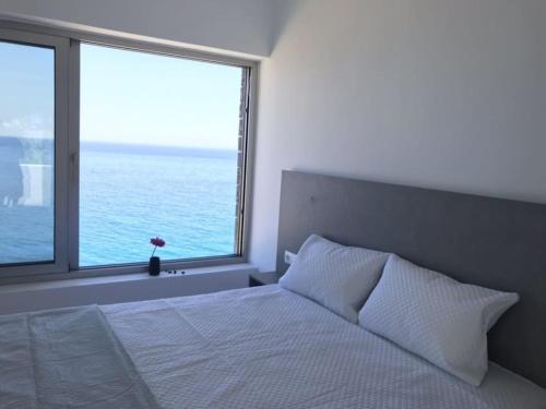a bedroom with a bed and a large window at Villa Avra in Ierápetra