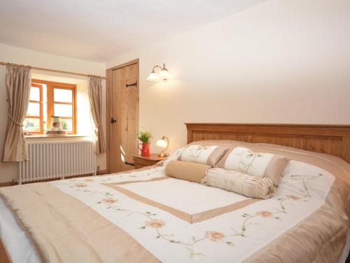 a bedroom with a large bed with a flower pattern at 1 Bed in Coleford 37217 in Bream