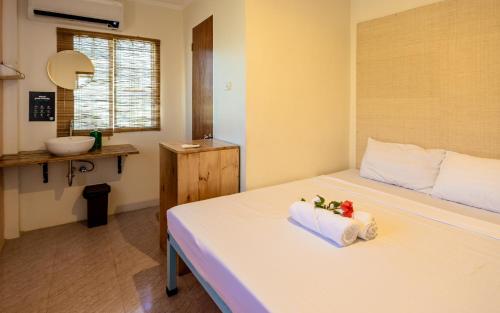 a bedroom with a bed with a towel on it at Mad Monkey Panglao in Panglao