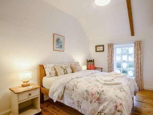 a bedroom with a bed and a table with a lamp at 5 Bed in Dereham 89542 in Swanton Morley