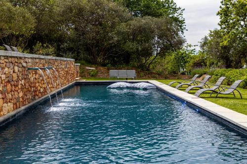a pool with a water slide in a yard at Plaisir Estate Accommodation in Simondium