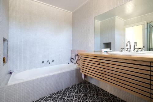 een witte badkamer met een bad en een wastafel bij Murramarang Haven in Bawley Point