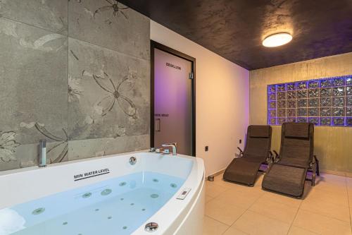 a bath tub in a room with two chairs at Wellness Resort Trebnje in Trebnje