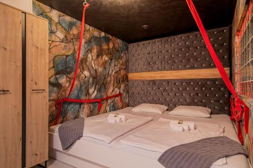 a bed in a room with red ropes around it at Wellness Resort Trebnje in Trebnje