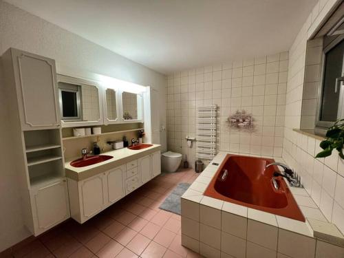 a bathroom with two sinks and a red tub at Chalet Maithili Lauterbrunnen -152-Year-Old Majestic Chalet in Lauterbrunnen