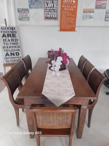 a wooden table with a vase of flowers on it at The Sangtus Home in Babakan Madang