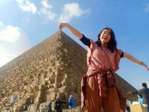 a woman standing in front of a pyramid at Eyad Pyramids view in Cairo