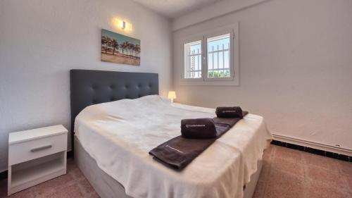 a bedroom with a bed with two towels on it at Costacabana - Villa Abigail in Lloret de Mar