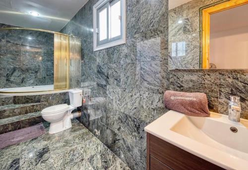 a bathroom with a sink toilet and a mirror at Costacabana - Villa Abigail in Lloret de Mar