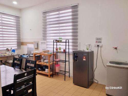 a kitchen with a refrigerator in the middle of a room at AfiRA Homestay Cherating in Kuantan