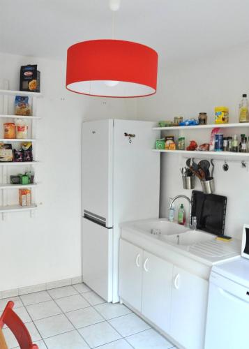 a kitchen with a white refrigerator and a red light at Le Vendôme in Lyon