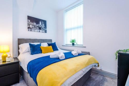 a bedroom with a large bed with towels on it at 5 Sleeper LFC Themed Apartment in Liverpool