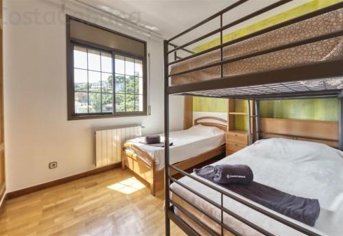 een slaapkamer met 2 stapelbedden en een raam bij Costacabana - Villa Paris in Lloret de Mar
