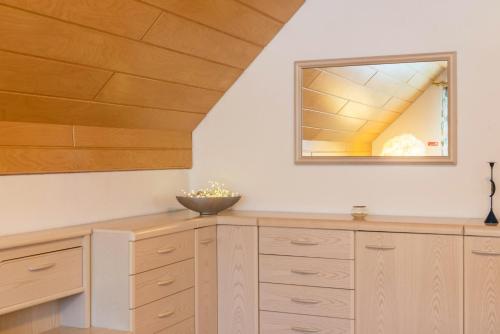 uma cozinha com armários de madeira e um espelho em Schwarzwalduhren Nescht Triberg em Triberg